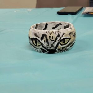 grey and white bangle with cat face with green eyes