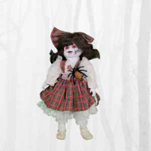 doll with plaid skirt and bow with spider crawling on front and blood and stitched cuts on face