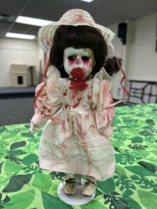 doll with eyes missing and bloody face and dress