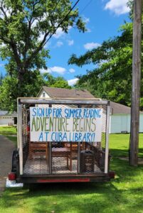 sign on back of float reading Sign up For summer Reading Adventure Begins At Cuba Library!