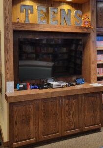 wood cabinets with large flat screen TV and game systems