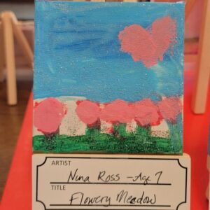 A colorful child’s painting showing a blue sky with a heart-shaped pink cloud and a field of pink flowers under a blue sky.