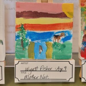 A colorful landscape painting featuring a sunset, river, green land, a tree, and a small brown animal on an easel.