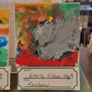 A small abstract painting with a central gray patch surrounded by red, orange, green, blue, and yellow colors.