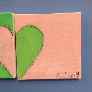 A canvas painting with a large green half heart shape on a pink background, with a signature in the bottom right.