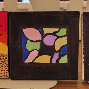 An abstract painting with colorful patches in a black border on a small square canvas.
