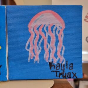 A small canvas painting of a pink jellyfish on a blue background.