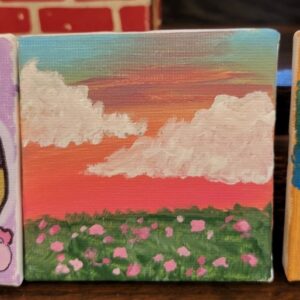 Small painting of a sunset with clouds and a field of pink flowers.