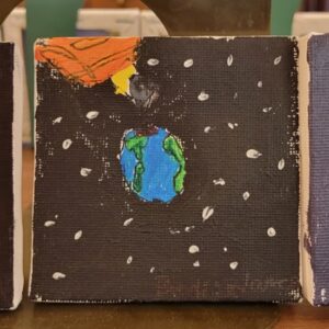 A small painting of Earth in space with a comet above and white specks representing stars.