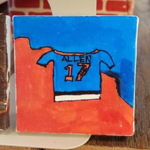A small canvas painting of a blue sports jersey with "ALLEN" and "17" on a red and blue background.