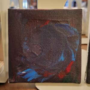 Abstract painting on a small canvas with dark colors and vibrant red, blue, and green swirls.