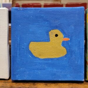A small canvas with a yellow duck with an orange beak on a blue background.