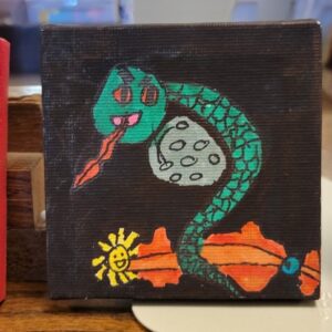 A colorful, stylized painting of a snake with an orange sun on a dark canvas.