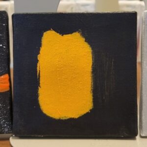 A small canvas with a textured black background and a yellow-orange brushstroke in the center.
