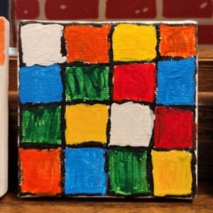 A painted grid on canvas resembling a section of a Rubik's Cube with colorful squares.