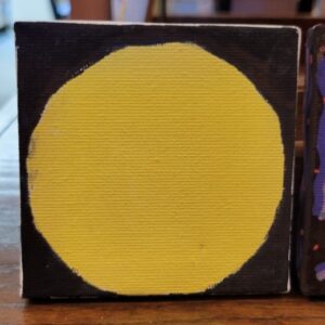 Small painting with black background and large yellow circle.