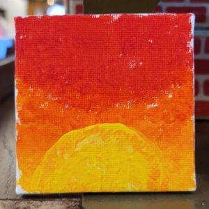 Abstract painting of a sunrise with red and orange sky, and a yellow sun.