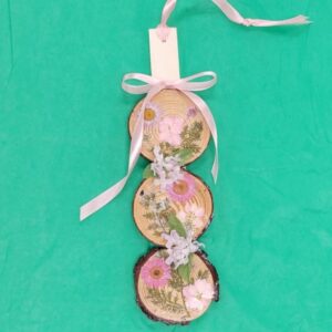 Decorative hanging with dried florals on wood slices and pink ribbon