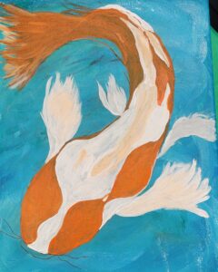 Koi fish swimming in blue water with orange and white patterns.